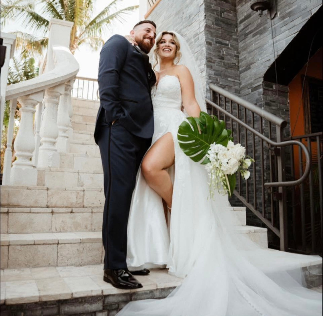Florida bride and groom wedding portrait on stone steps with bouquet by Glow & Go Beauty